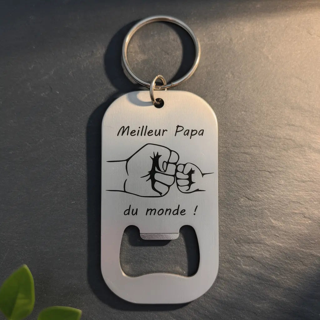Porte-clés décapsuleur en acier inoxydable gravé “Meilleur Papa du monde” avec poing illustré et ouvre-bouteille intégré.